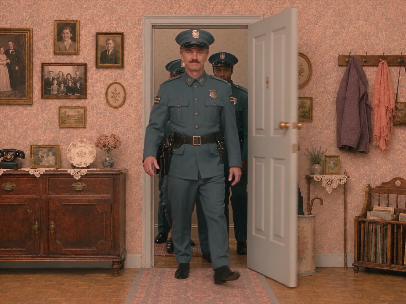 Still from Wrong Apartment: uniformed officers filing in through the apartment door