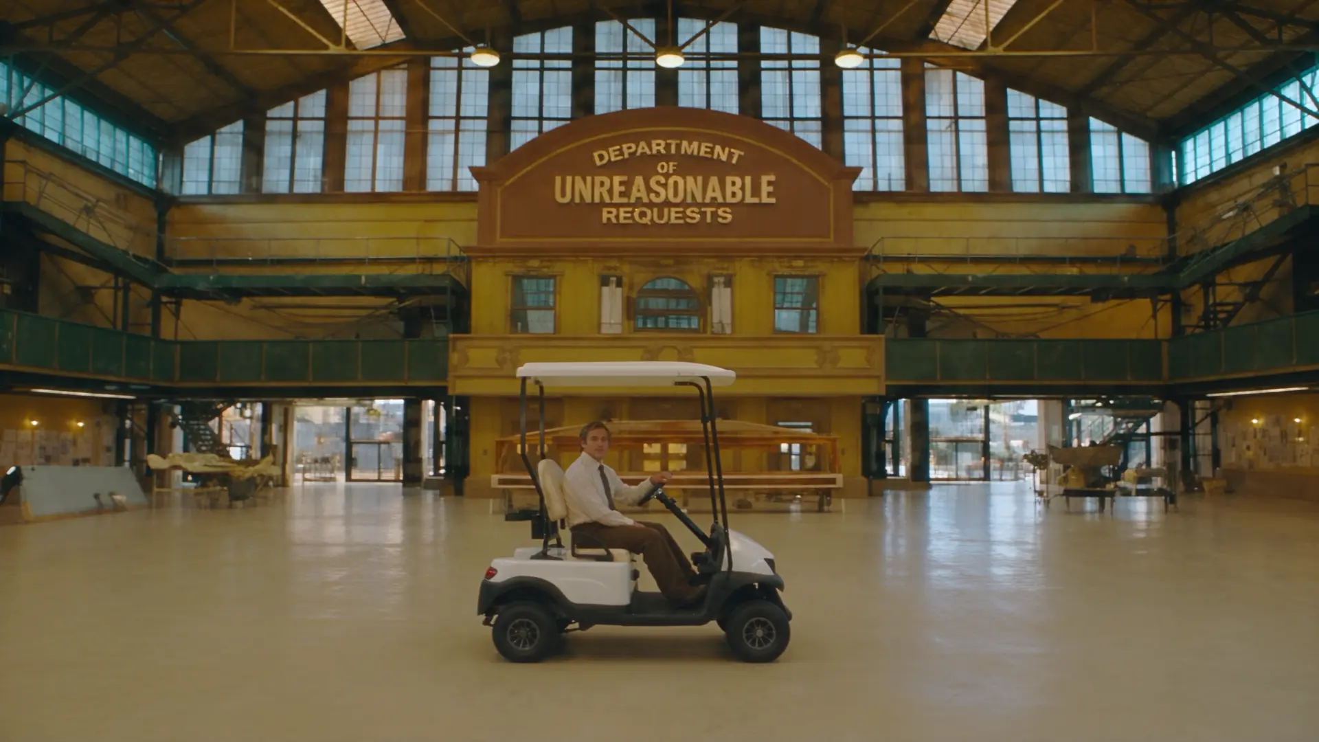 Still from Introducing Rocco Studio: a man in a golf cart outside the Department of Unreasonable Requests
