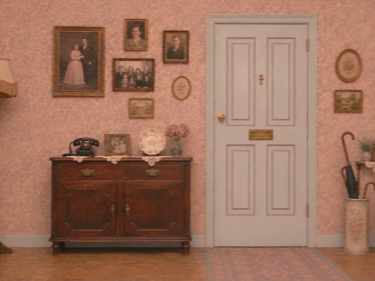 Still from Wrong Apartment: an empty floral-wallpapered hallway with a closed front door